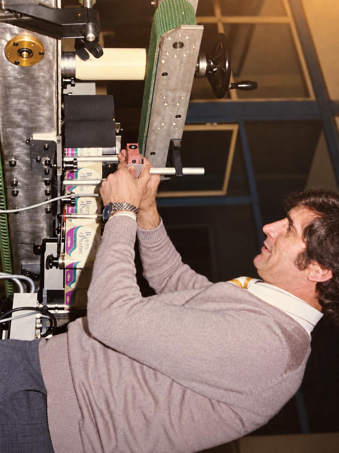 Esteban García ajustando una máquina de etiquetado.